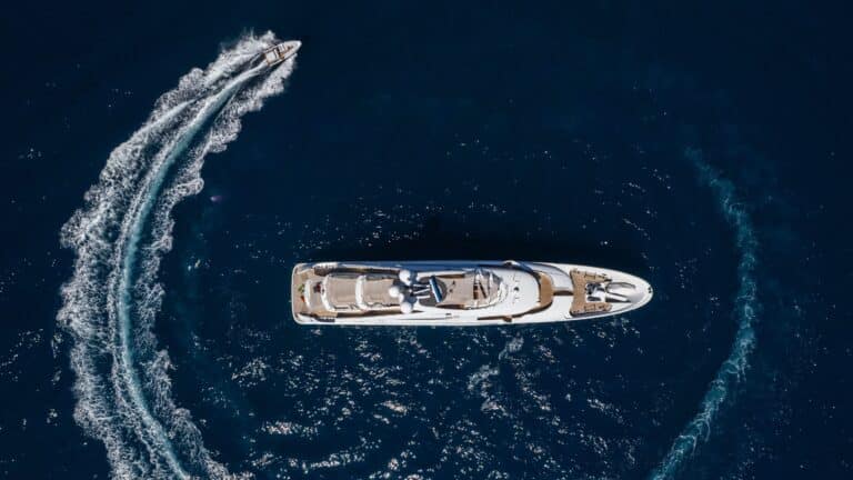 Aerial view of a yacht with a wakeboarder