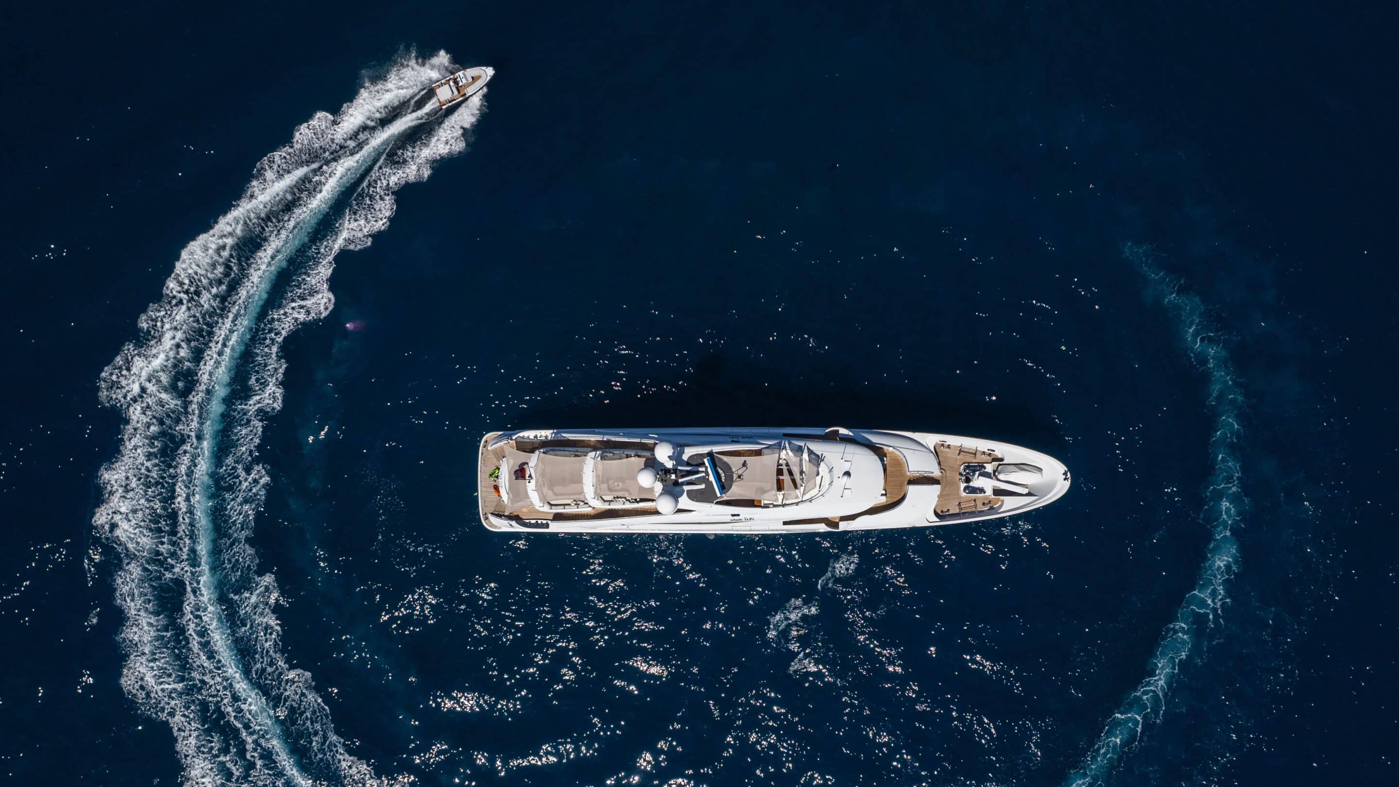 Aerial view of a yacht with a wakeboarder