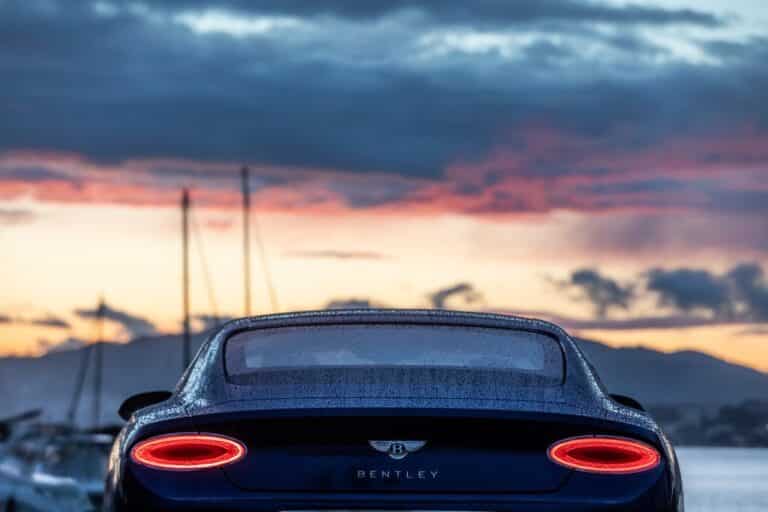 Car parked on a quay facing yachts
