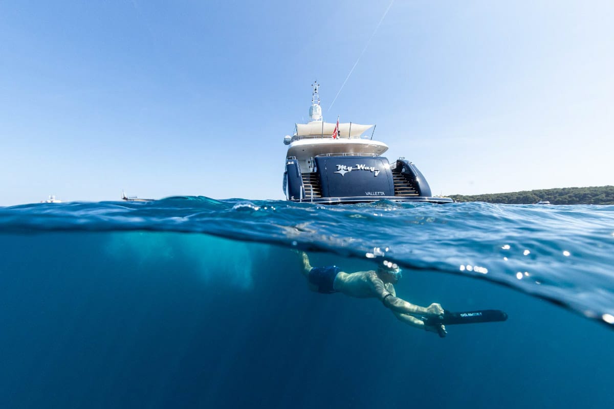 Swimmer underwater beneath the yacht MyWay