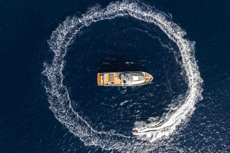 Aerial view of a yacht drawing a circle in the water