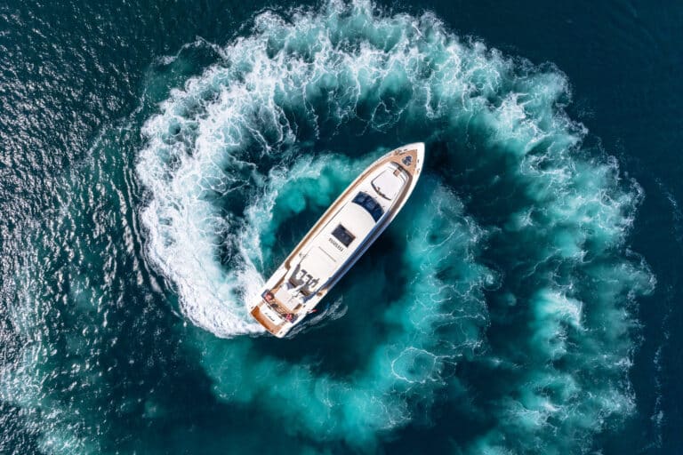 Aerial view of a yacht turning in its wake