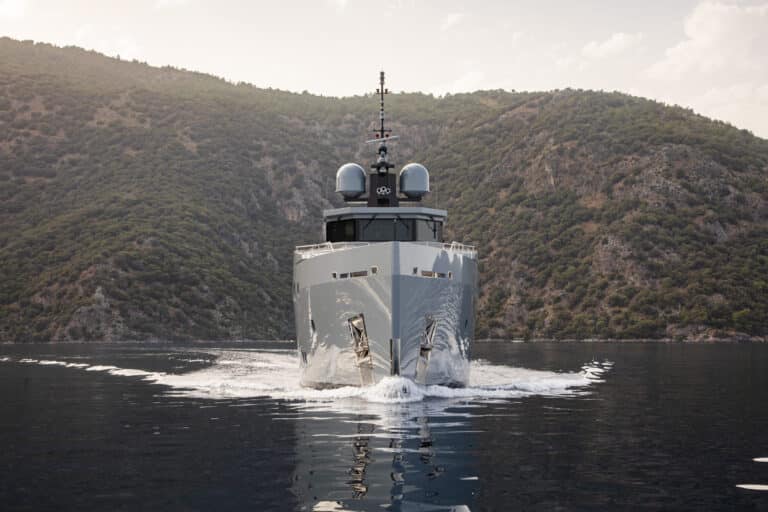 Yacht cruising along green hills