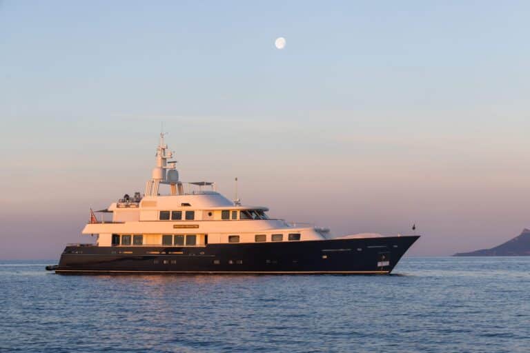 Yacht at dusk with the moon in the sky