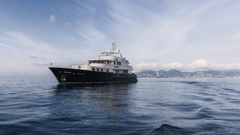 Yacht at sea with the hills behind